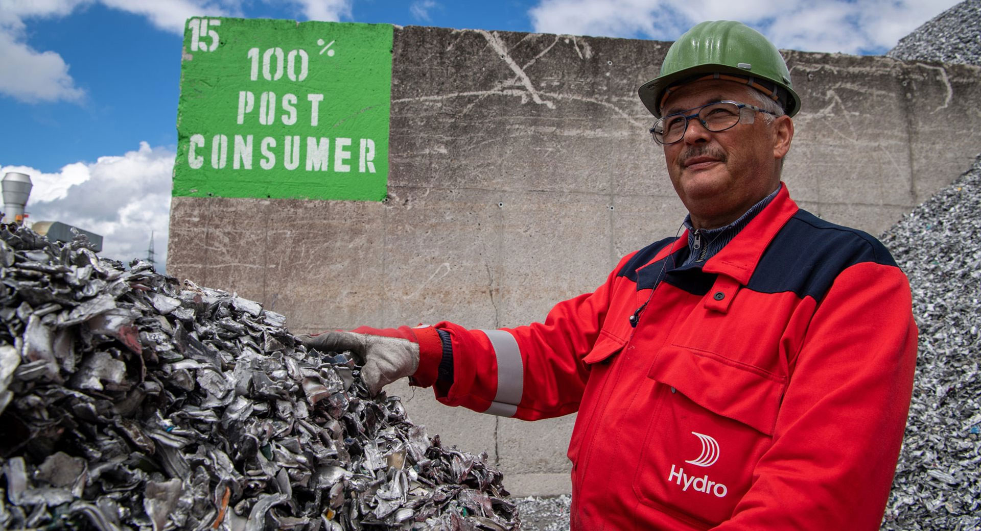 a man wearing a red jacket and hat standing in front of a sign
