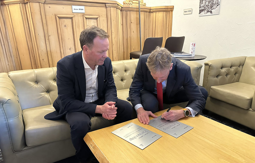 a person showing a person signing a partnership