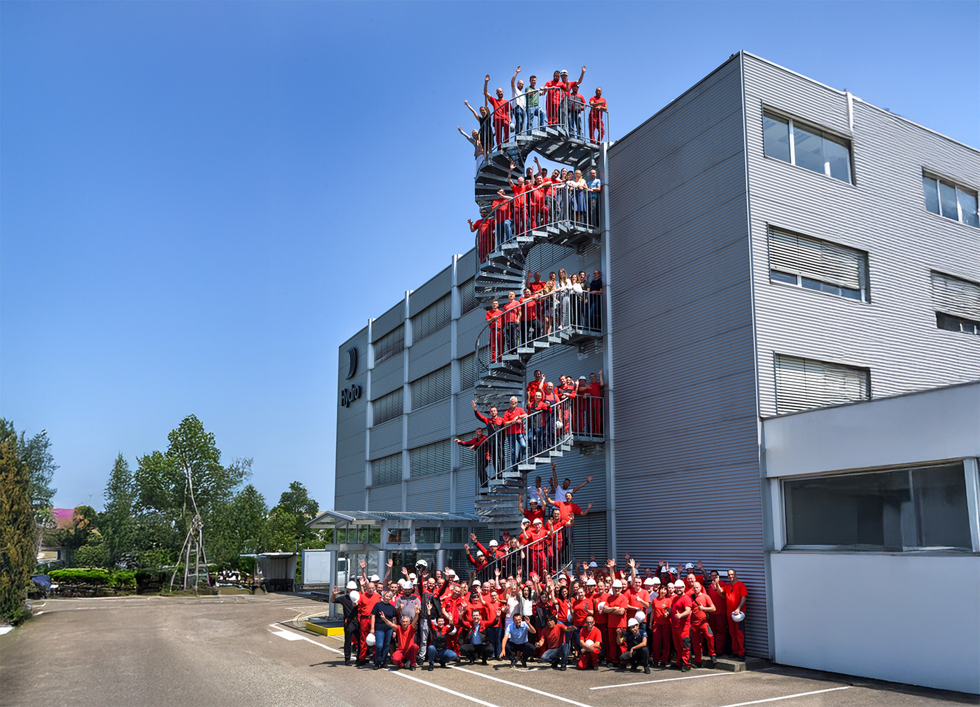 a group of people in red uniforms standing in front of a building