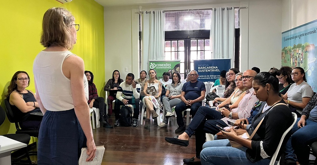 a woman standing in front of a group of people sitting in chairs