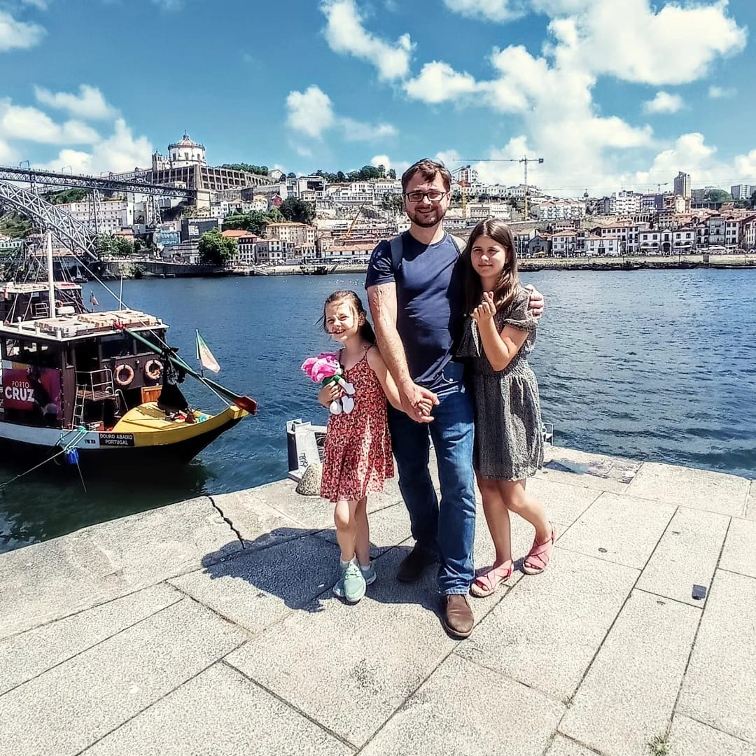 a group of people posing for a photo on a dock by a body of water